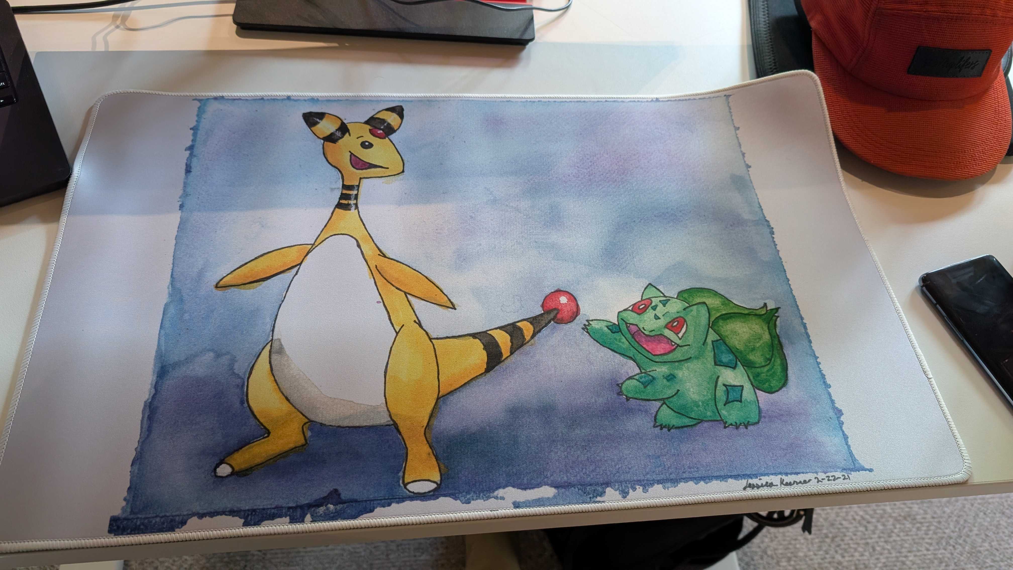 A custom white playmat with a watercolor painting of Ampharos and Bulbasaur on top of gradient blue background