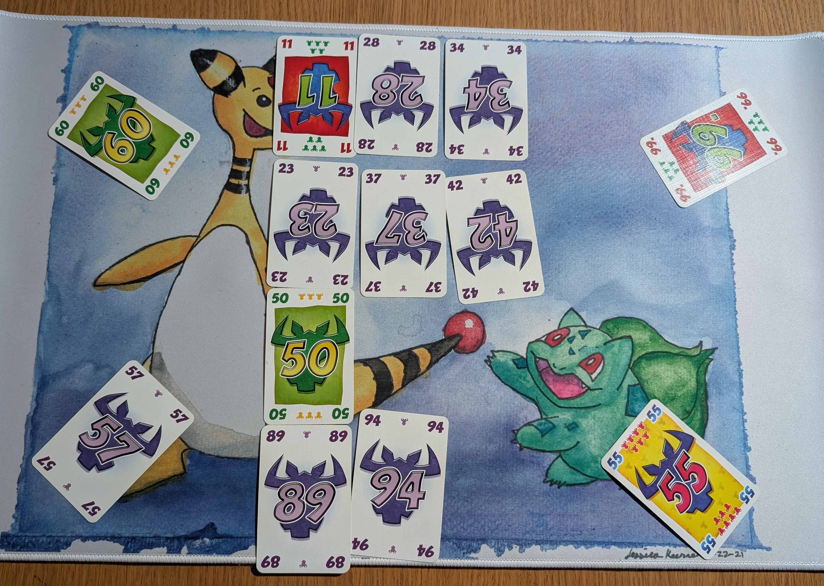 A game of 6 Nimmt on-going with four rows of 1 to 3 cards in each. Four cards valued 60, 99, 55 and 57 have been played by different players.