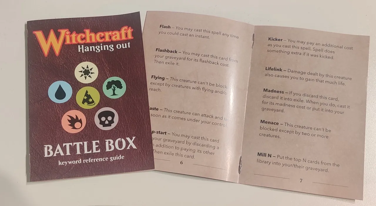 A booklet for Witchcraft Hanging Out, a Battle Box keyword reference guide with non-official Magic the Gathering mana symbols. A second copy of the booklet is open on a spread with 10 keywords and their explanations.