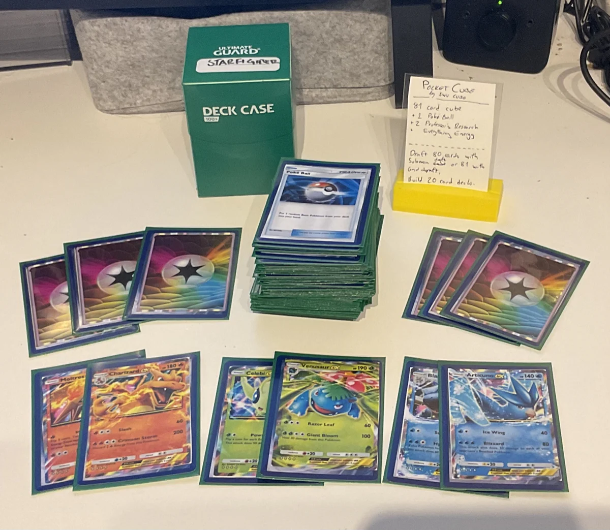 A deck of Pokemon TCG Pocket cards sleeved with a few custom everything energies and ex cards laid out on a table, including Charizard ex, Venusaur ex and Articuno ex