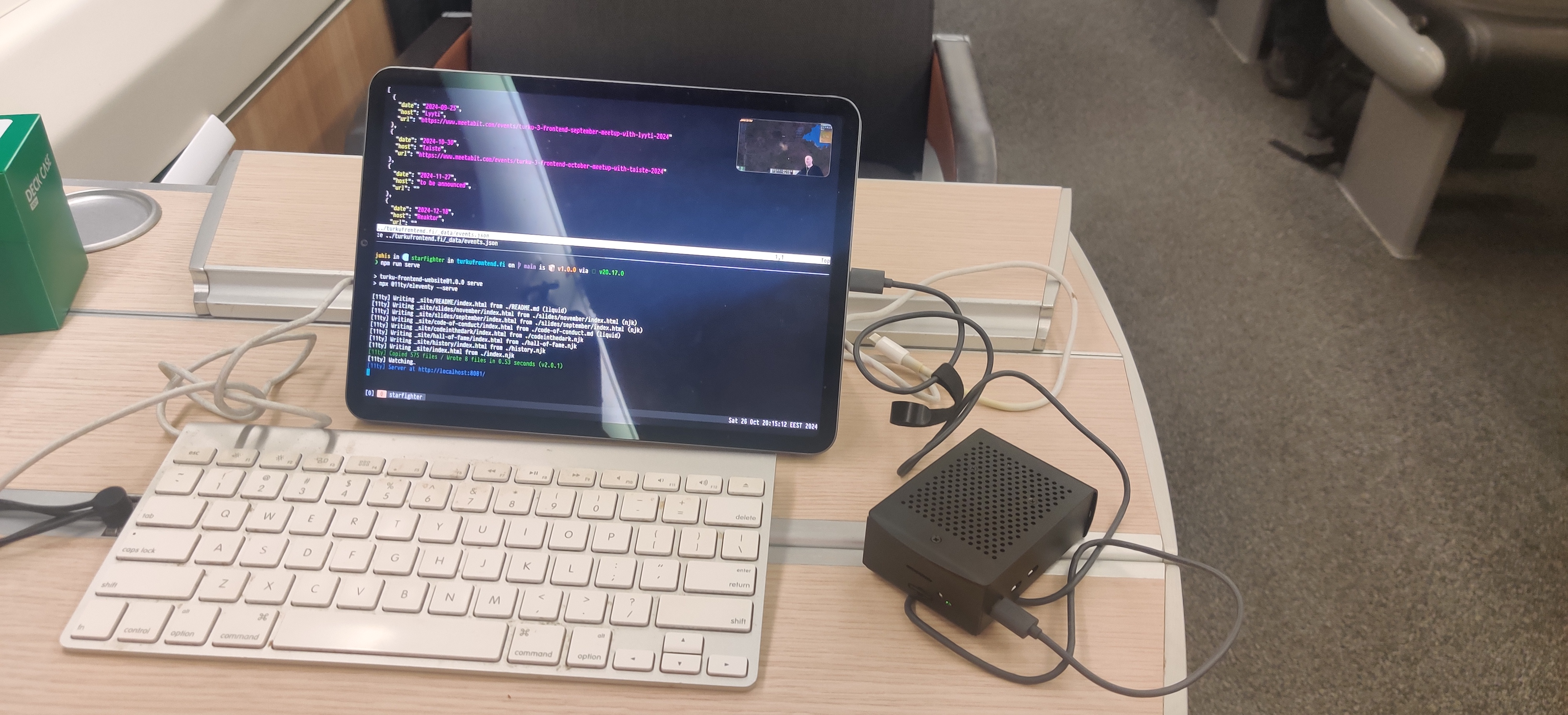 Raspberry Pi connected to iPad and an extra keyboard in a table in a train.