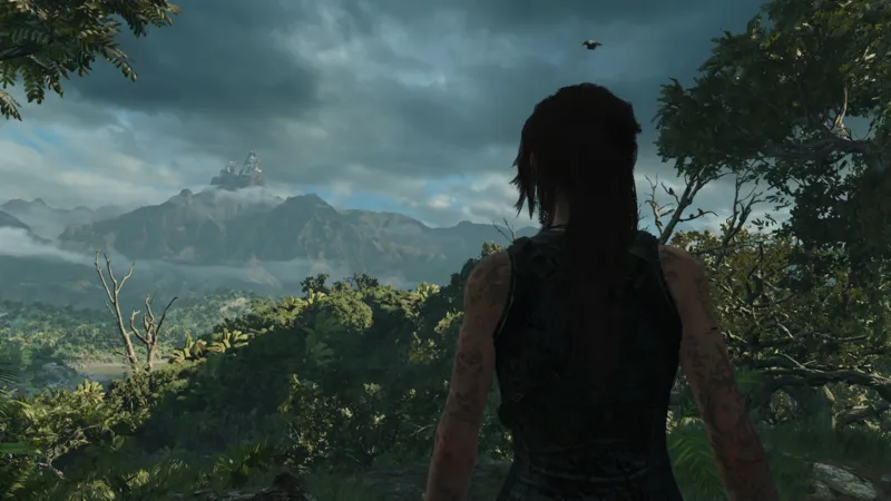 Lara Croft looking towards a valley of jungle and majestic mountains under dark clouds in the distance.