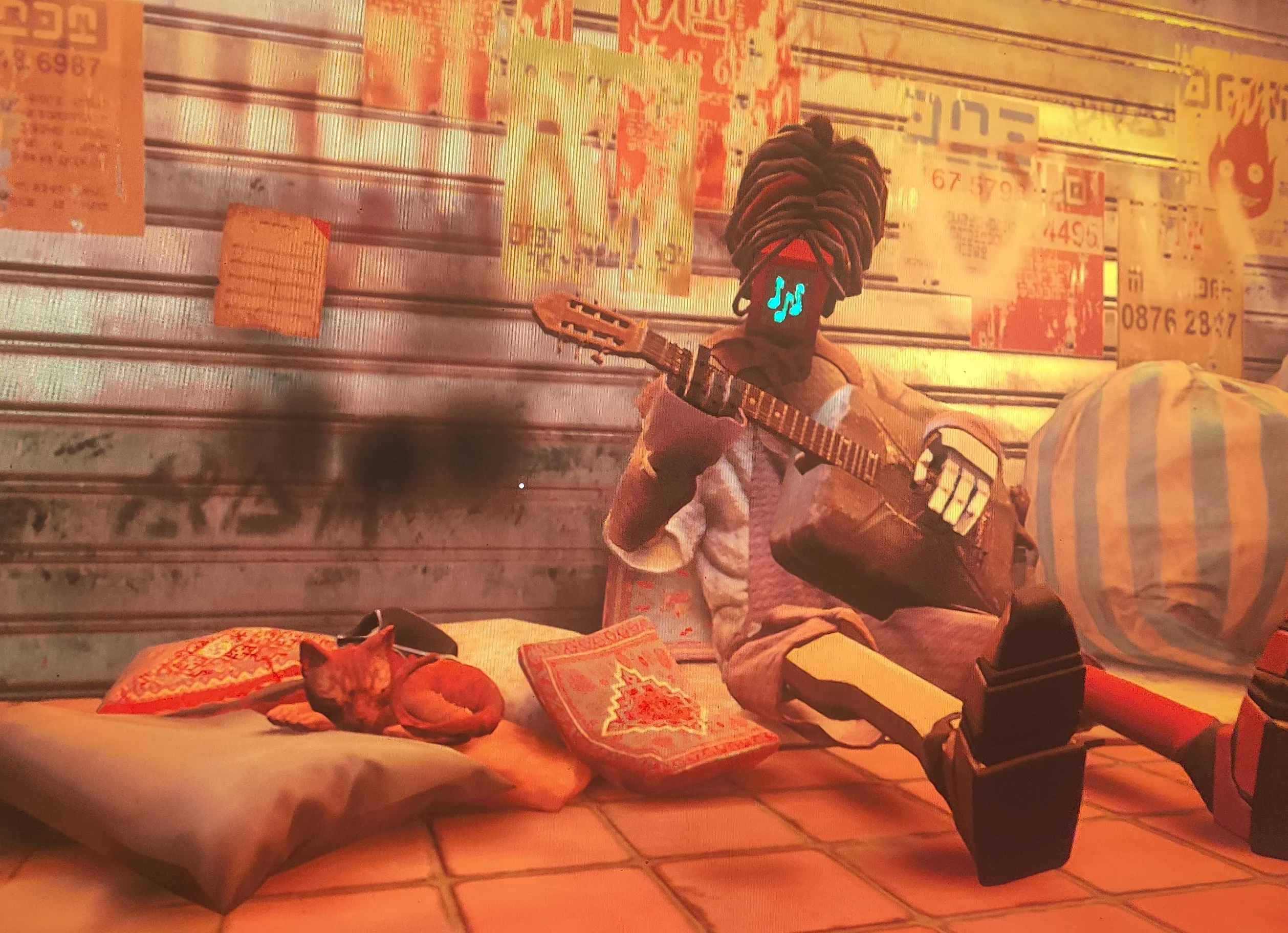 A cute, orange video game cat sleeping on a pillow next to a robot musician who is playing a makeshift guitar made from a gas canister. The robot's face is three music notes. They are both in front of a closed garage door that has bunch of posters and graffiti on it.